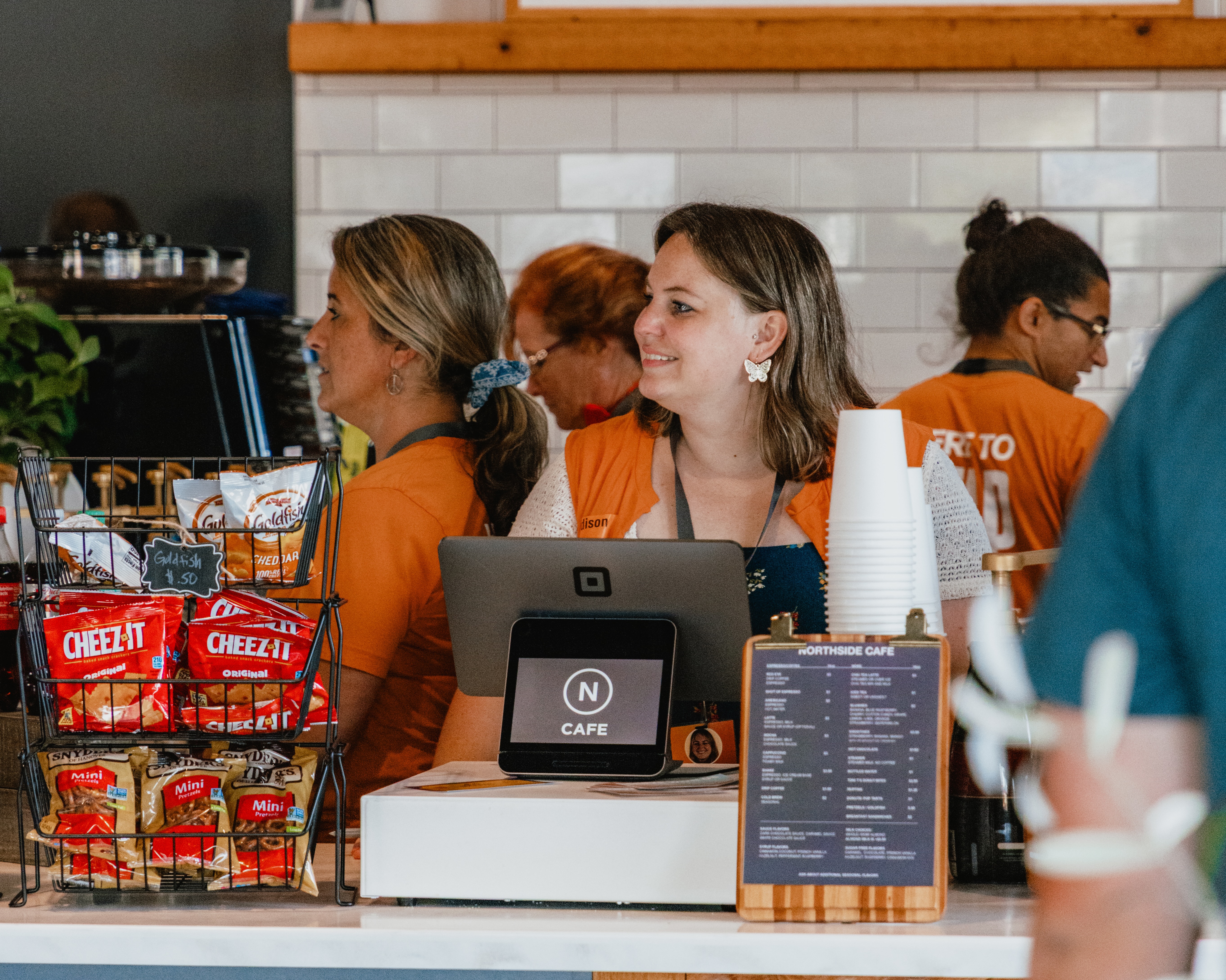 A barista at a cafe checkout counter